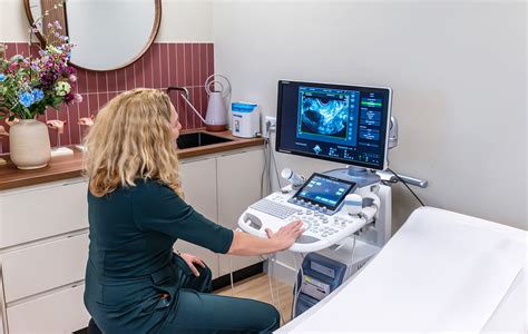 een verloskundige die een echo maakt van een zwangere buik
