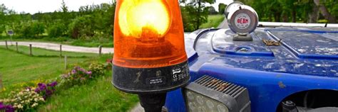 Illustratie van diverse tractor accessoires zoals een zwaailicht, aanhanger, voorlader en kruiwagen.