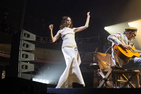 PJ Harvey in een dramatische pose op het podium.