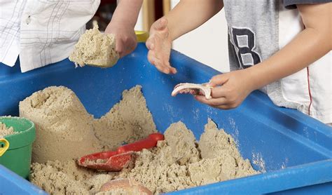 Een kind dat speelt met zand en water in een sensorische tafel.