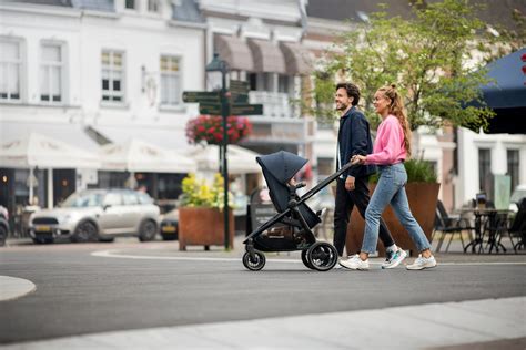 Afbeelding van een ouder die een Kinderkraft kinderwagen eenvoudig inklapt voor transport.