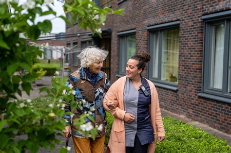 Professionele draagconsulente die een ouder helpt met het aanmeten van een draagzak