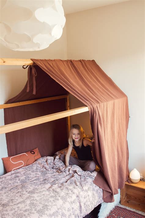 Een kinderkamer met het LÖVA hemeltje boven een bed, wat een gezellige en rustige sfeer creëert.