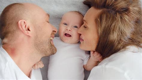 Foto van een gezin met een pasgeboren baby, met een kraamverzorgende op de achtergrond