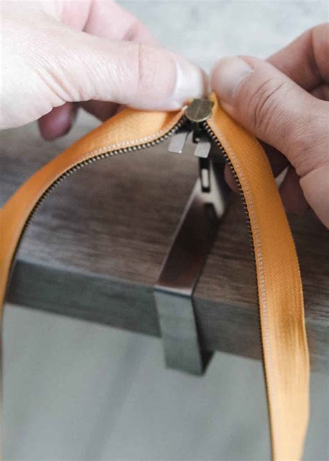 Illustratie die de verstelbare ritsen en het geheime vakje van de puffer voetenzak toont