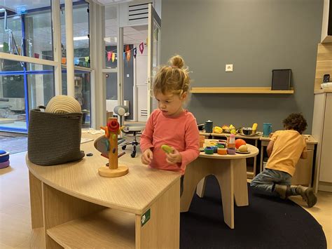 Een kind speelt geconcentreerd met een houten Viga keukenset, wat creativiteit en rollenspel stimuleert.