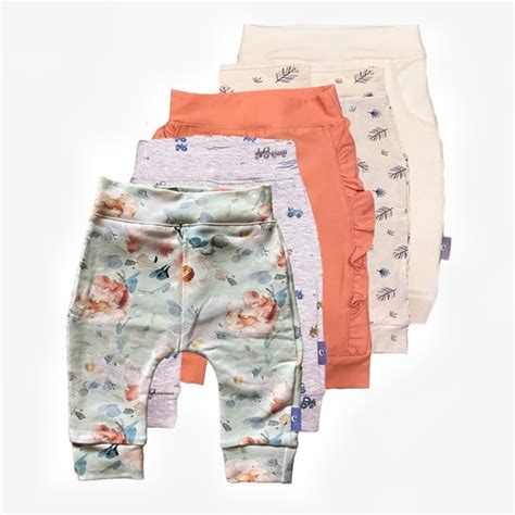 Collectie van zachte, premature kledingstukken zoals rompertjes, broekjes en mutsjes in kleine maten.