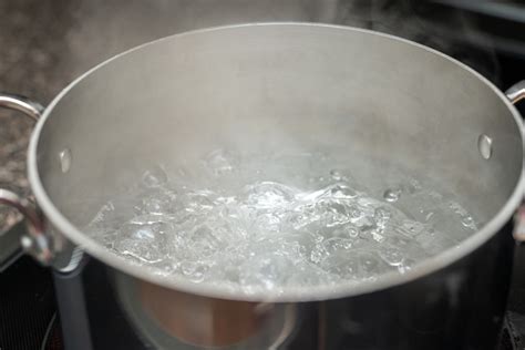 Een steelpan met kokend water en een fopspeen erin