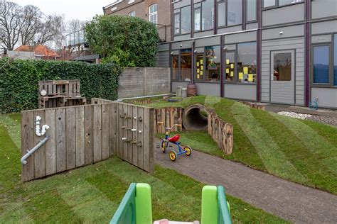 Illustratie van de groene tuin van kinderdagverblijf Het Groene Kroontje, met kinderen die spelen.