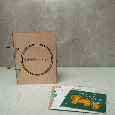 Een gepersonaliseerde houten bewaarbundel voor geboortekaartjes.