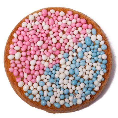 Een selectie van kleurrijke cupcakes en donuts, deels met roze en blauwe muisjes, klaar voor een gender reveal party.