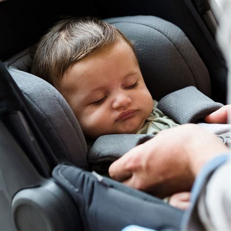 Close-up van een baby die comfortabel slaapt in een Maxi-Cosi reiswieg