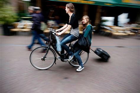 Kinderen die vrolijk op de fiets zitten, met op de achtergrond een stadse omgeving.