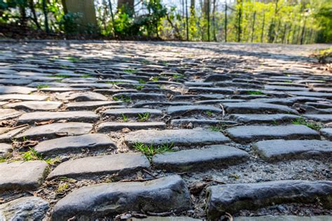 Infographic met symbolen die verschillende ondergronden aangeven (glad asfalt, kasseien, hobbelige weg) en een pijl die de voorkeur voor glad asfalt aangeeft.