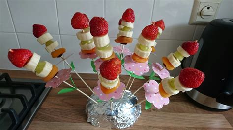 Een spies met druiven, eindigend met een aardbei, vormt een vrolijke rups.