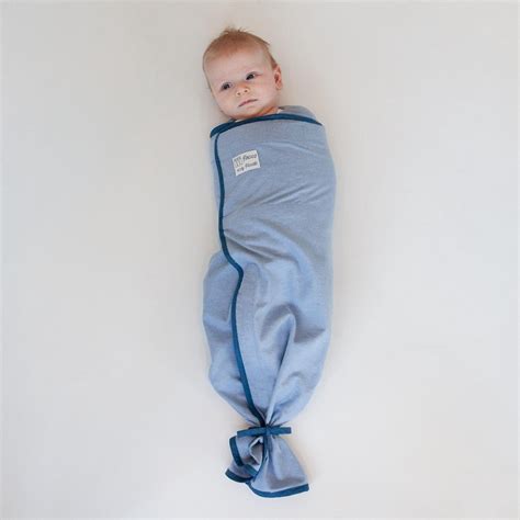 Illustratie van een baby die veilig in een Pacco inbakerdoek ligt, met nadruk op de vrije benen en het vrije hoofd.