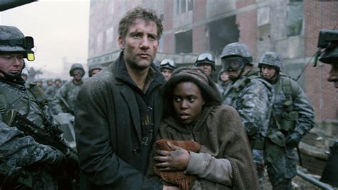Een scène uit 'Children of Men' met Clive Owen die een zwangere vrouw beschermt in een chaotische omgeving.