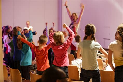 Groep lachende kinderen die samen zingen met instrumenten