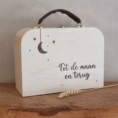 Een selectie van gepersonaliseerde babycadeaus, zoals een koffertje met tekst en babysokjes.