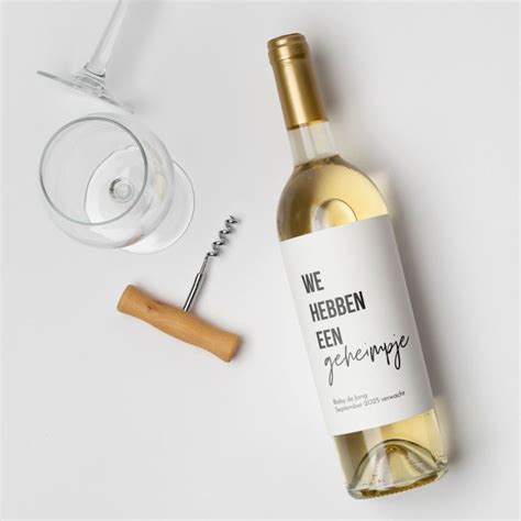 Een fles wijn met een gepersonaliseerd etiket dat de zwangerschap aankondigt.