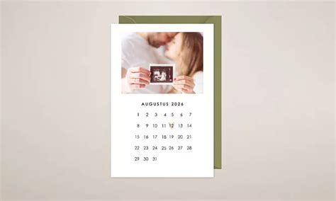 Een fotolijst met een zwangerschapsaankondigingstekst en een kalender met een gemarkeerde uitgerekende datum.