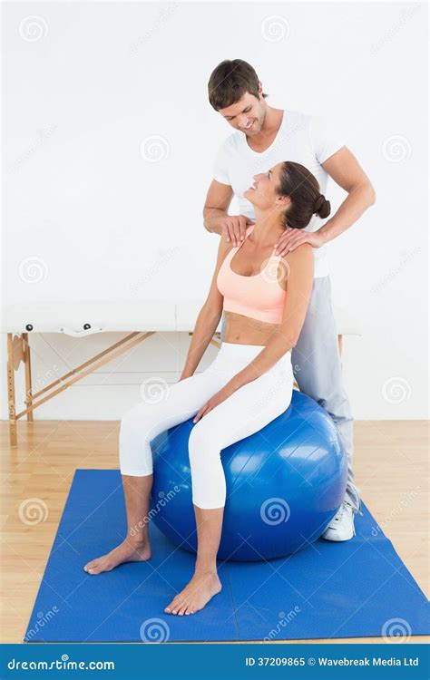 Een vrouw die weeën opvangt op een yogabal, met een partner die haar ondersteunt