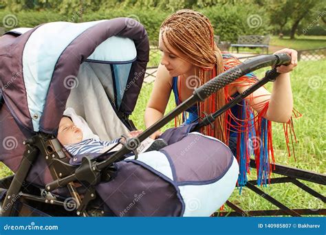 Baby en moeder doen oefeningen met kinderwagen in het park