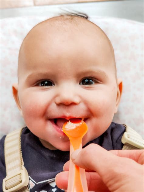 Baby die met een lepeltje pap eet