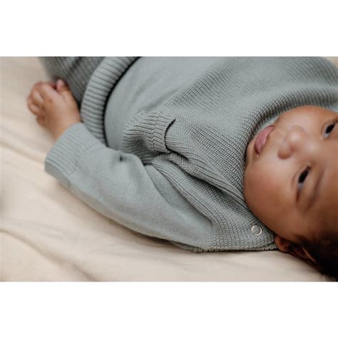 Detail van babykleding met stretch broekje en drukknoopsluiting op een trui.