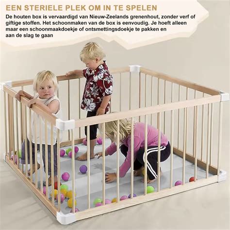 Een kleurrijke en veilige babyruimte met een grondbox, speelkleden en diverse ontwikkelingsstimulerende materialen.