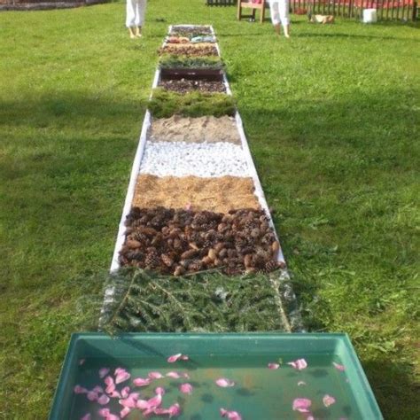 verschillende bakken gevuld met natuurlijke materialen voor een blotevoetenpad