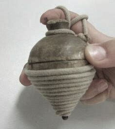 Illustratie van hoe een priktol met een touwtje wordt afgewikkeld om te spinnen