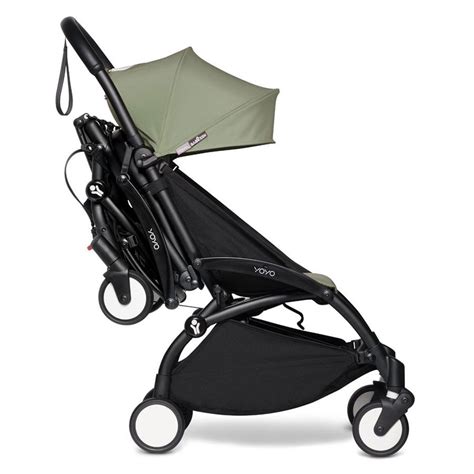 Babyzen YOYO³ buggy ingeklapt, klaar om over de schouder gedragen te worden.